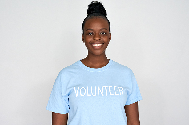 Migrant Support Charity in New Cross and London smiling young woman wearing a blue volunteer t shirt